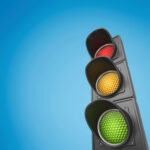 Closeup of traffic lights against blue sky background